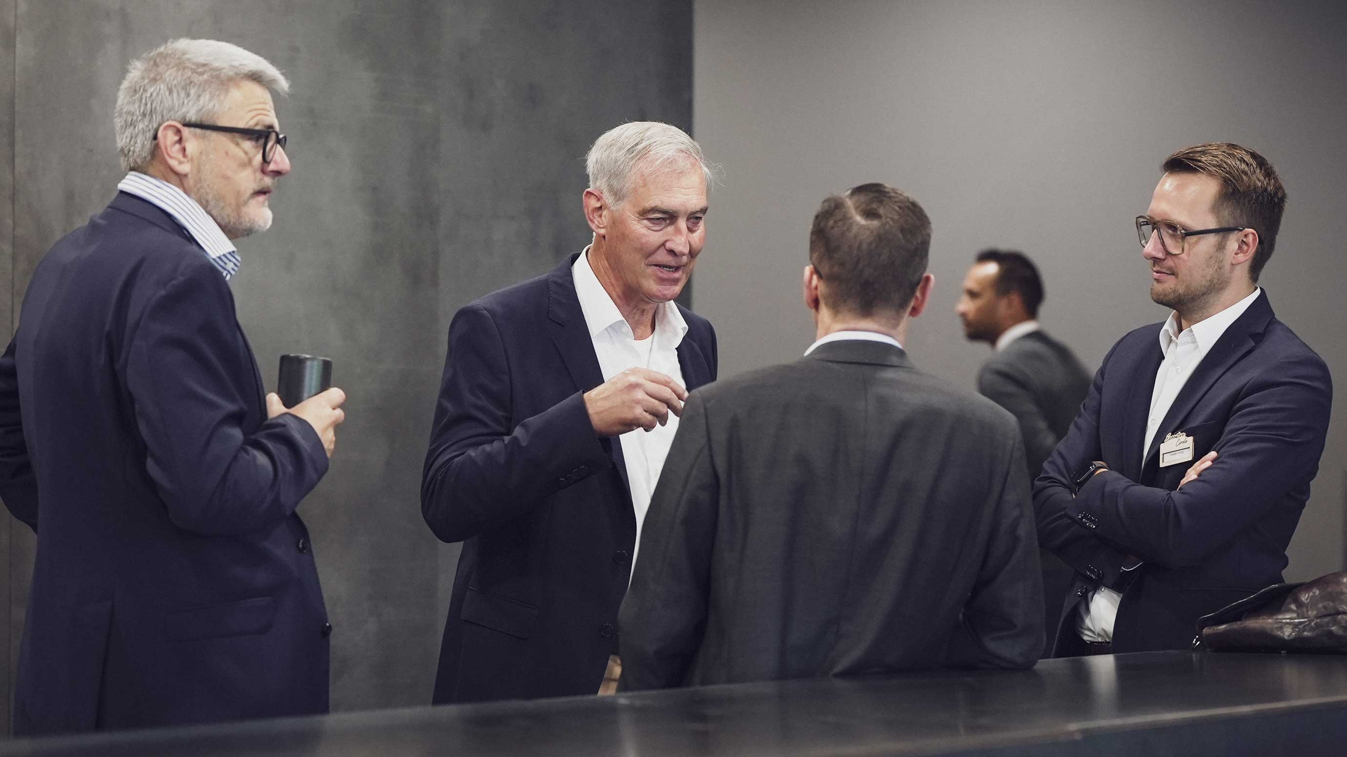 Vier Männer in Anzügen diskutieren während des EUROGUSS Executive Circle, einer Konferenz für Führungskräfte der Druckgussbranche